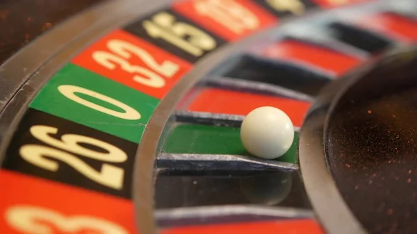Ball on roulette table in casino. Wheel spinning, turning, rotating. Green zero. Stock Photo