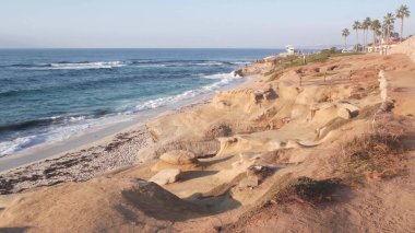 Sahildeki okyanus dalgaları, aşınmış uçurum veya kayalık, La Jolla, Kaliforniya kıyıları, ABD.
