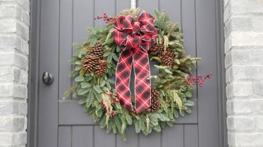 Çam ağacından ya da köknar ve kırmızı kurdeleli yeşil Noel çelengi..