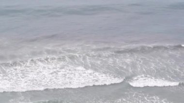 Pelikan kuşları havada uçuyor, okyanus dalgaları. Pelecanus uçuşu, su yüzeyi.