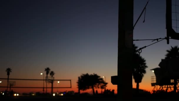 Silueta de red de voleibol en cancha deportiva de playa al atardecer, costa de California, EE.UU.. — Vídeos de Stock