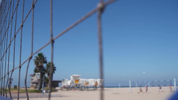 Люди играют в волейбол на пляже, хижина спасателей на песчаном побережье Калифорнии, США — стоковое видео