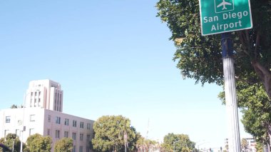 Havalimanı yeşil yol işareti, yönü ok ve uçak ikonu, San Diego şehir sokağı, Kaliforniya ABD. Turistik yerler, trafik işaretleri. Yerel ve uluslararası seyahat kavramı. Şehir merkezi binası.