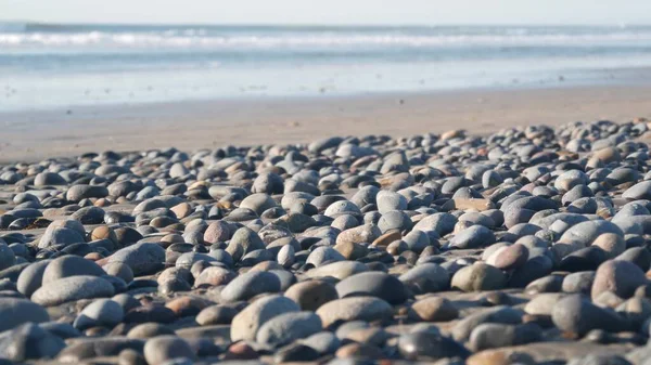 在沙滩上的卵石被海浪冲刷 圆圆的光滑石子或卵石低角视点柔和 加州海岸度假美感 带有Bokeh的海景自然背景 — 图库照片