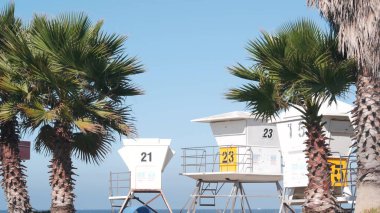 Cankurtaran standı ve palmiye ağacı, Kaliforniya sahillerinde sörf yapmak için can kurtaran kulesi. ABD 'de yaz Pasifik Okyanusu. Kurtarma istasyonu, sahil cankurtaranı Wachtower kulübesi ya da deniz evi. Kusursuz döngülü görüntü grafiği