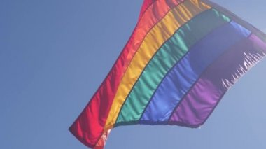 Rüzgarda dalgalanan gökkuşağı LGBTQ bayrağı, renkli bayrak çizgileri. Eşit hakların, cinsel azınlıkların, cinsiyet farklılığının ve eşcinsel gururunun sembolü. Lezbiyenler, biseksüeller, transseksüeller ve homoseksüeller birliği