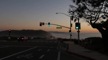Pasifik sahili otoyolu 1, Torrey Pines eyalet plajı, Del Mar, San Diego, Kaliforniya ABD 'de trafik ışıkları. Sahil seyahatleri. Okyanus boyunca 101 numaralı otoyolda yolculuk. Akşam alacakaranlıkta arabalar