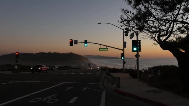 美国加利福尼亚州圣地亚哥德尔马的托里松州海滩1号太平洋海岸高速公路上的交通灯 沿海公路度假 在101号高速公路上沿着大海的路途旅行 黄昏时分的汽车 — 图库视频影像