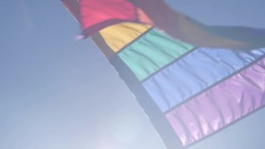 Rüzgarda dalgalanan gökkuşağı LGBTQ bayrağı, renkli bayrak çizgileri. Eşit hakların, cinsel azınlıkların, cinsiyet farklılığının ve eşcinsel gururunun sembolü. Lezbiyenler, biseksüeller, transseksüeller ve homoseksüeller birliği