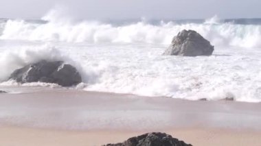Büyük Pasifik okyanus dalgaları kumlu sahillere çarpıyor, doğanın gücü, deniz kabaran su kıyıya vuruyor. Garrapata Parkı, Big Sur, California sahili, ABD. Deniz manzarası ve kayalar, sisli hava.