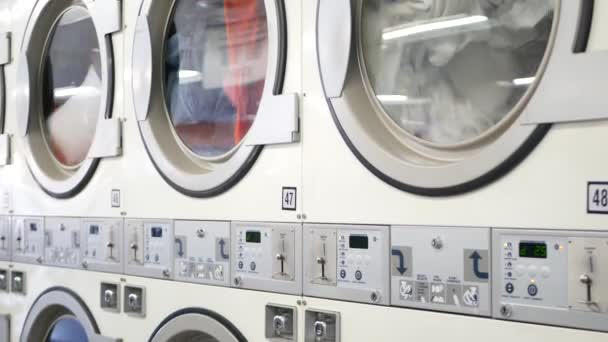 Mosó- és szárítógépek sora, pénzmosás Kaliforniában, USA-ban. Önkiszolgáló mosodában vagy kereskedelmi mosodában használt mosógépek és szárítók. Automatikus mosás az Egyesült Államokban.
