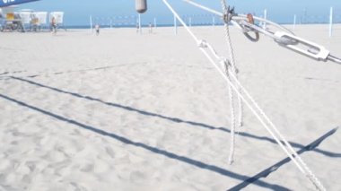 İnsanlar plajda voleybol oynuyor, Kaliforniya sahilinde cankurtaran kulübesi, ABD. Açık hava spor sahası, oyun alanı ya da kumlu sahildeki kort. San Diego 'daki Mission plajında ağ ve top ile eğlence oyunu.