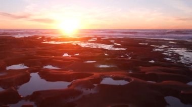 Erimiş kaya oluşumu, La Jolla, California sahilinde gel-git havuzu, ABD. Kelimenin tam anlamıyla gelgit bölgesi erozyonu, tidehavuzun alışılmadık rahatlama şekli. Çürük su, oyuklar ve taş yüzeyde delikler, günbatımı gökyüzü