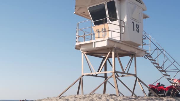 Mentőállvány vagy mentőtorony kunyhó, szörfözés a kaliforniai tengerparton, USA. A Csendes-óceán nyári esztétikája. Mentőállomás, partmenti életmentők wachtower vagy ház homokon. Piros ATV Mission Beach-en.