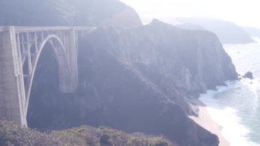 Bixby Creek Köprüsü, kemer mimarisi. Pasifik kıyısı otoyolu 1 dönüm noktası. Tarihi manzaralı Cabrillo yolu. Sahil yolculuğu, yolculuk ya da okyanus yoluyla seyahat. Sisli havada kanyon. California, Big Sur, ABD