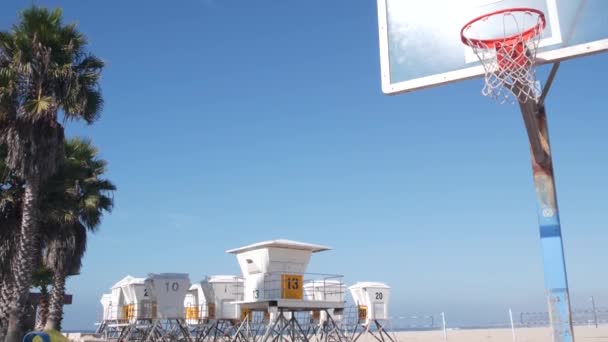 美国加利福尼亚海滨的棕榈树和篮球场或球场 海滩上的街球游乐场和救生员看台 任务海滩 圣地亚哥 背板和天空 — 图库视频影像