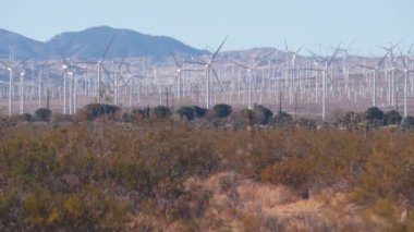 Dönen yel değirmenleri türbini, rüzgar çiftliği veya elektrik santrali alternatif yeşil yenilenebilir enerji jeneratörleri, Kaliforniya 'daki sanayi bölgesi, Mojave Çölü, Tehachapi, ABD. Rüzgâr çiftliğinde elektrik üretimi.