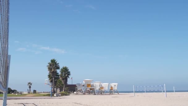 在美国加州海岸海滩排球赛的场地上打排球网 圣地亚哥任务区海滩上沙滩海岸 救生站和棕榈树上运动员的运动场地或游乐场 — 图库视频影像