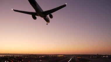 Gece havaalanı pist ışıkları, uçak ya da uçak iniş pisti, alacakaranlık ve günbatımı. Uçak jeti havaalanına geliyor, San Diego havaalanı, Kaliforniya ABD. Gökyüzünde havada uçan uçaklar.