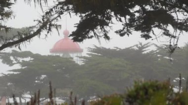Pinos eski tarihi deniz feneri mercekleri parlıyor, sisli yağmurlu kötü hava. Aydınlatılmış antika ışık evi ya da fener kulesi, sisli selvi çam ağacı ormanı. Monterey, Kaliforniya kıyısı ABD