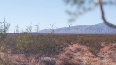 Dönen yel değirmenleri türbini, rüzgar çiftliği veya elektrik santrali alternatif yeşil yenilenebilir enerji jeneratörleri, Kaliforniya 'daki sanayi bölgesi, Mojave Çölü, Tehachapi, ABD. Rüzgâr çiftliğinde elektrik üretimi.