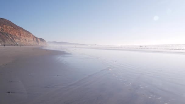 陡峭的悬崖 岩石或悬崖 加利福尼亚海岸侵蚀 德尔马 圣地亚哥 人们沿着侵蚀的峭壁在海滨沙滩上行走 托里松树州的海滩 低潮的水波 多雾的天气 — 图库视频影像