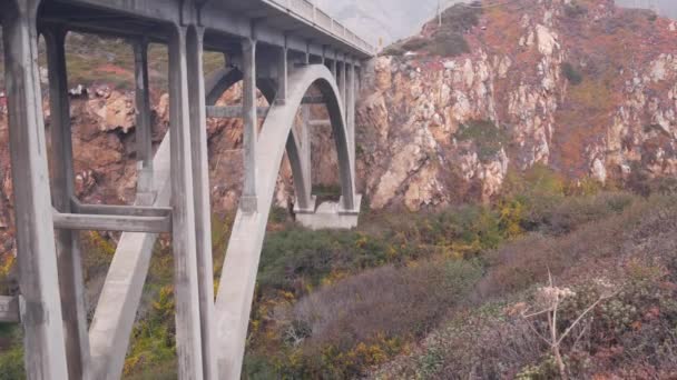 大峡谷河流上的拱桥 太平洋海岸公路风景秀丽的公路 加州公路旅行 美国大苏尔自然 卡夫里洛1号公路 沿着大海的旅游路线 高架桥下陡峭的悬崖或岩石 — 图库视频影像