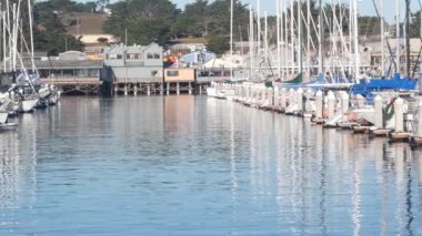 Yığınlar, sütunlar, okyanus körfezi ya da liman, deniz suyu üzerindeki renkli ahşap evler. Old Fishermans Rıhtımı. Kaliforniya, Monterey Marina 'da yatlar, yelkenli tekneleri. Turist sahili gezisi.