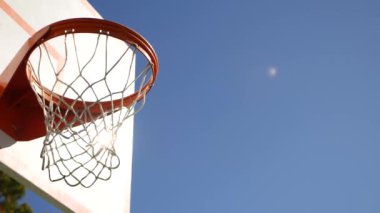 Basketbol sahası, turuncu halka, beyaz ağ ve dışarıda basket maçı için sedye. Sokak arasında eğlence amaçlı spor ekipmanları, ABD caddesinde oyun alanı. Mavi gökyüzü arkaplanı.