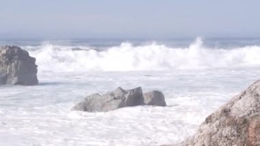 Büyük Pasifik okyanus dalgaları kumlu sahillere çarpıyor, doğanın gücü, deniz kabaran su kıyıya vuruyor. Garrapata Parkı, Big Sur, California sahili, ABD. Deniz manzarası ve kayalar, sisli hava.