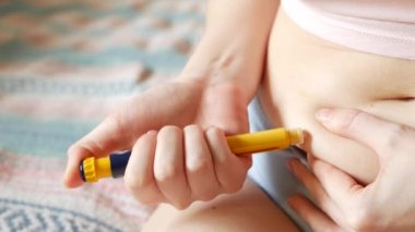 Kadın mideye, karnına ya da karnına iğne yapıyor. Tüplü döllenme, üreme kısırlığı, kısırlık tedavisi. Hormonal ilaçlar, yumurtlama uyarılması. Ensülin enjekte eden kadın, diyabet.