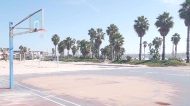 Basketbol sahası, basket maçı için basketbol sahası, ağ ve pota, Kaliforniya sahilleri, ABD. Sokak basketbolu ya da netbol oyuncuları için spor sahası, okyanus kıyısındaki palmiye ağaçları. Mission Sahili, San Diego.