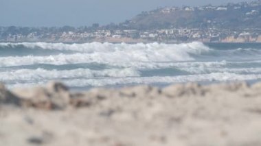 Büyük mavi okyanus dalgaları Kaliforniya Pasifik Sahili, ABD 'ye çarpıyor. Deniz suyu köpüğü ve beyaz kum. Yaz kıyı estetiği. Sörf atmosferi, Los Angeles yakınlarında deniz manzarası. Kusursuz döngülü görüntü grafiği.