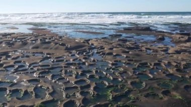 Erimiş kaya oluşumu, La Jolla, California sahilinde gel-git havuzu, ABD. Kelimenin tam anlamıyla gelgit bölgesi erozyonu, tidehavuzun alışılmadık rahatlama şekli. Çürük su, oyuklar ve taş yüzeydeki delikler, alçak gelgit.