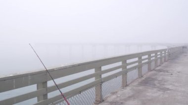 Ocean Beach İskelesi sisli Kaliforniya kıyılarında, ABD. San Diego sahilinde sisli, karamsar, bulutlu bir hava. Sakin, sessiz bir atmosfer. Rıhtımda. Balıkçılık ya da eğlence oltası.