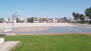 Basketbol sahası, basket maçı için basketbol sahası, ağ ve pota, Kaliforniya sahilleri, ABD. Sokak basketbolu ya da netbol oyuncuları için spor sahası, okyanus kıyısındaki palmiye ağaçları. Mission Sahili, San Diego.