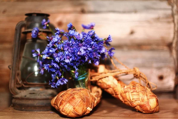Starožitný olejová lampa a modré květy — Stock fotografie