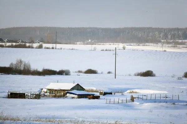 Pueblo en invierno, el campo cubierto de nieve, bosques y casas de madera —  Fotos de Stock