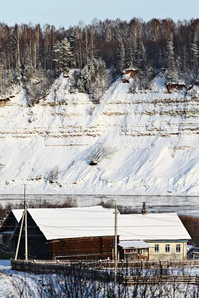 Dorf im Winter, die schneebedeckte Landschaft, Wald und Holzhäuser — Stockfoto