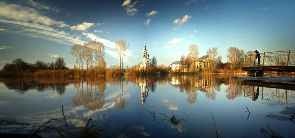 川と空の景色の銀行上の教会 — ストック写真