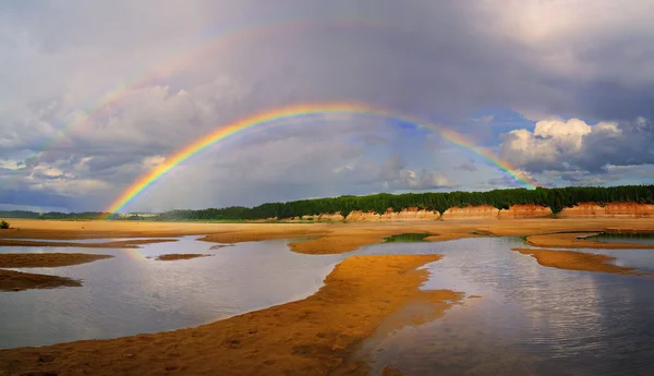 Двойная радуга над рекой — стоковое фото