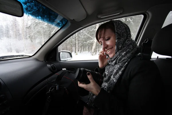 Fotografin sitzt im Auto und behält das Objektiv — Stockfoto