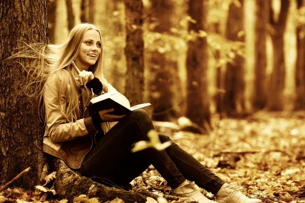 Joven hermosa chica con un libro en el bosque de otoño — Foto de Stock