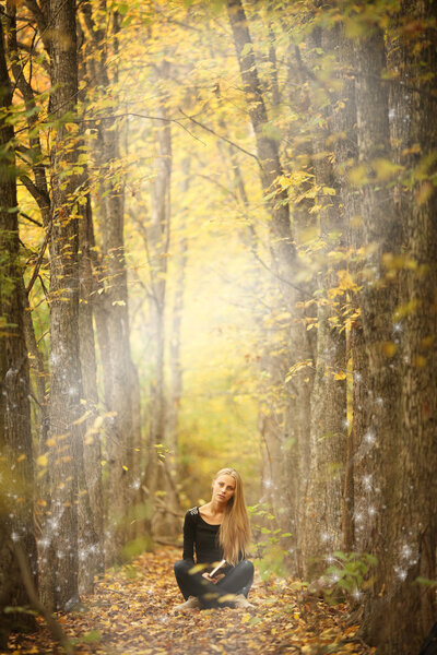 Girl with a book in the autumn forest