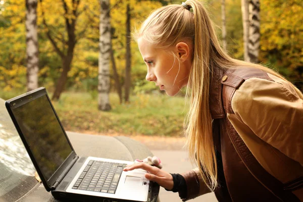 Vacker flicka med en laptop på natur — Stockfoto