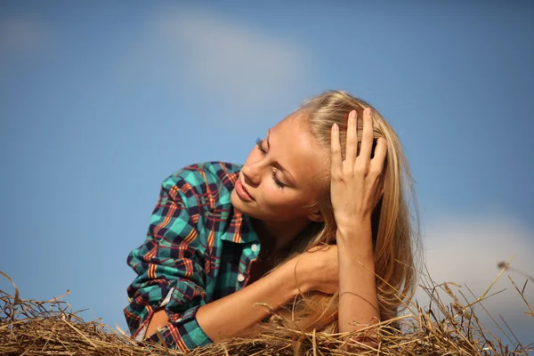 Ung vacker blondin i höet utomhus — Stockfoto