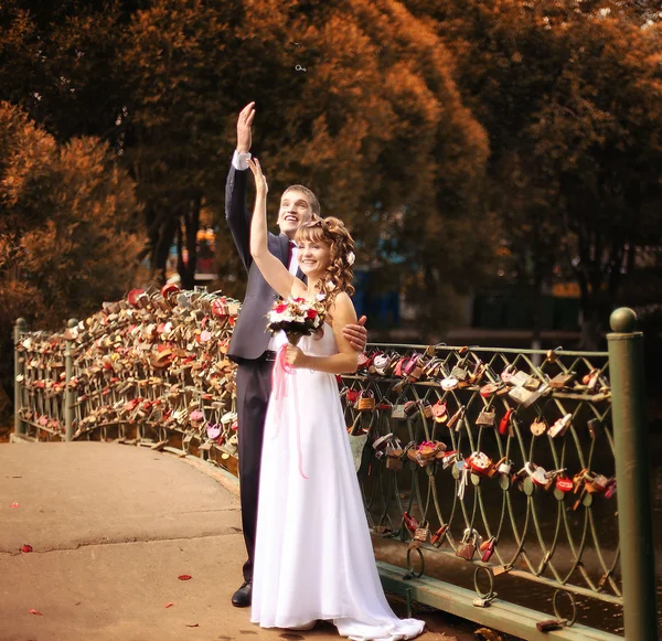 Bruid en bruidegom gooien de sleutel tot de sluis in het water, de Russische traditie — Stockfoto