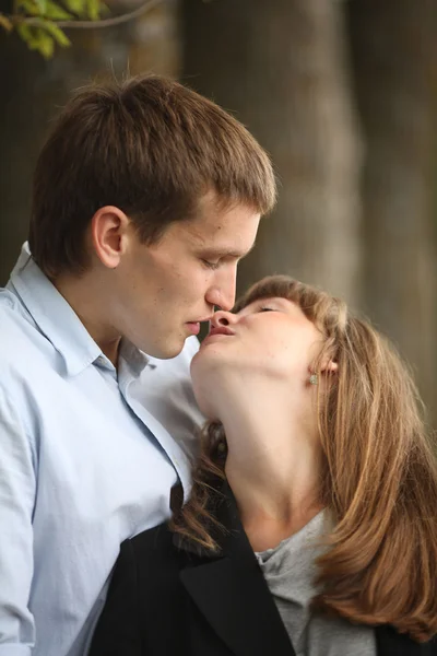 Omarmen en jonge jongen en meisje kussen op de natuur — Stockfoto
