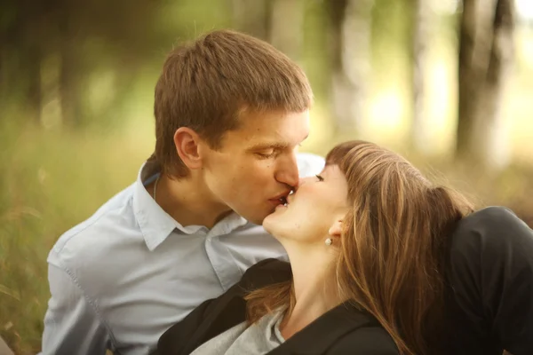 Abraçando e beijando o cara e a menina na natureza — Fotografia de Stock