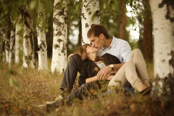 Omfamnar och kysser ung kille och tjej på natur — Stockfoto